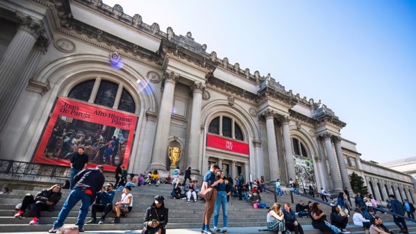  The image depicts the exterior of a grand neoclassical building, likely a museum, with large columns and arched windows. The building features a red banner on the left side that reads "Juan de Pareja" and "Afro Hispanic Palmer," indicating an exhibition. The steps in front of the building are crowded with people, some sitting and others standing, enjoying the sunny day. A golden statue is visible near the entrance. The sky is clear and blue, suggesting a pleasant day. The scene is lively, with people engaging in various activities, such as taking photos and conversing.</p>

<p>Provided by @altbot, generated privately and locally using Ovis2-8B